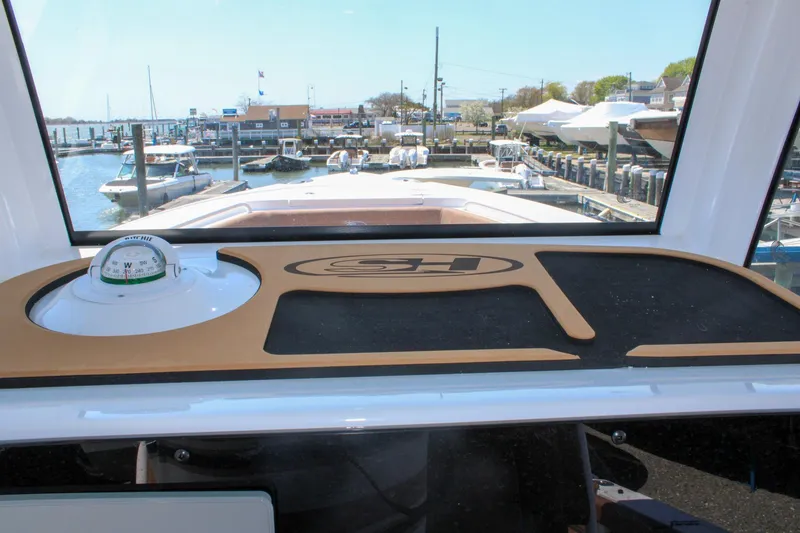 Slide: The Image of Interior view of 2026 Sea Hunt Ultra 255 SE boat, featuring a compass and dashboard. - 23