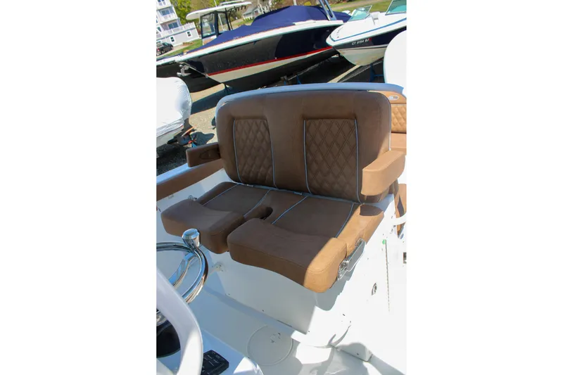 Slide: The Image of Luxurious seating on 2026 Sea Hunt Ultra 255 SE boat, featuring brown cushioned upholstery. - 26