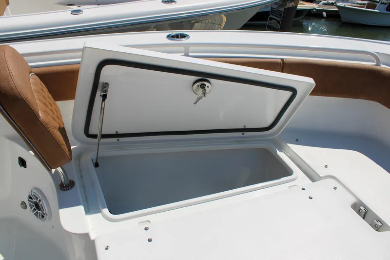 Slide: The Image of 2026 Sea Hunt Ultra 255 SE boat storage compartment with open lid and cushioned seating. - 32