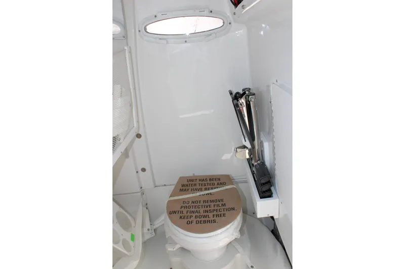 Slide: The Image of Interior of 2026 Sea Hunt Ultra 255 SE boat, featuring a compact marine toilet. - 35