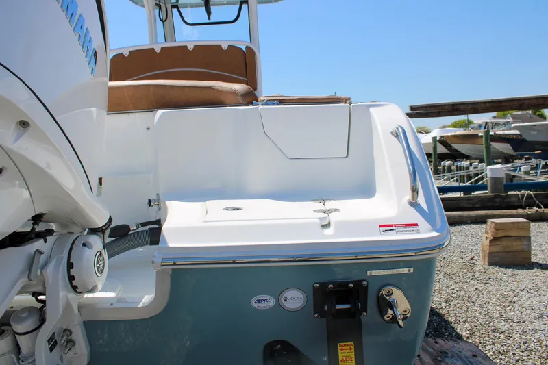 Slide: The Image of 2026 Sea Hunt Ultra 255 SE boat stern with Yamaha engine, docked on gravel. - 4