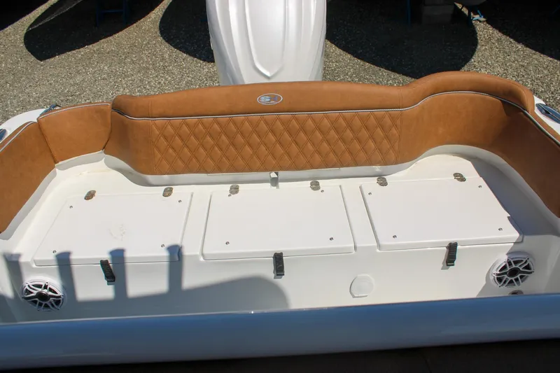 Slide: The Image of 2026 Sea Hunt Ultra 255 SE boat interior with tan cushioned seating and storage compartments. - 6