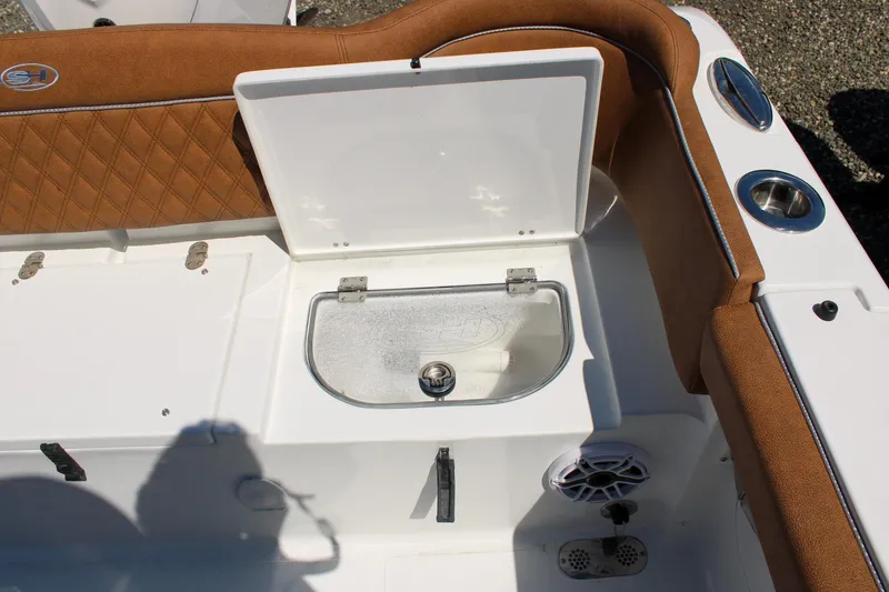 Slide: The Image of Livewell on 2026 Sea Hunt Ultra 255 SE boat with brown seating and cup holders. - 7