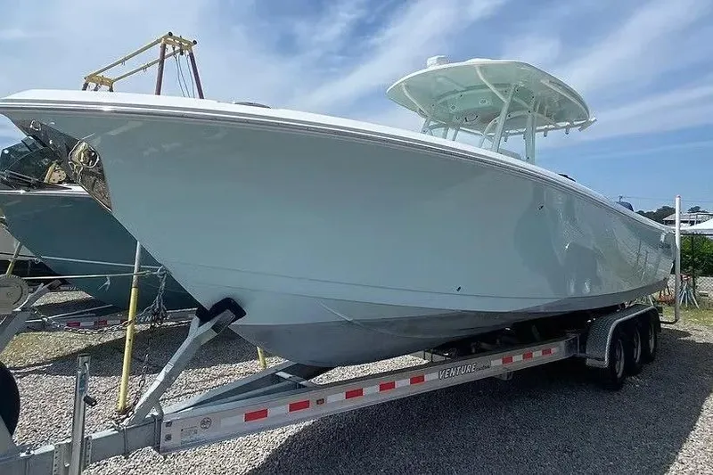 The Image of 2022 Sailfish 290 CC boat on trailer under clear sky. - 1