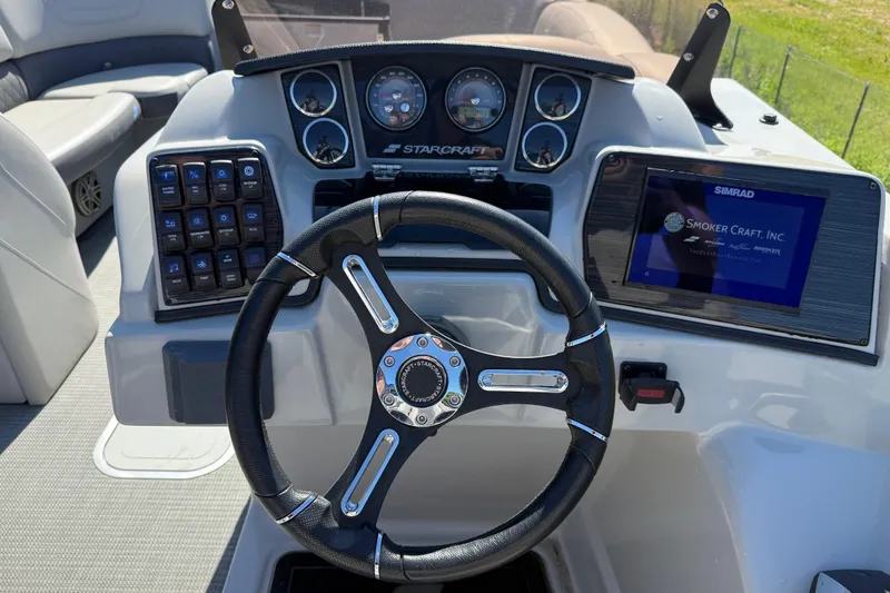 Slide: The Image of 2023 Starcraft SLS 5 boat dashboard with steering wheel, gauges, and Simrad display. - 10