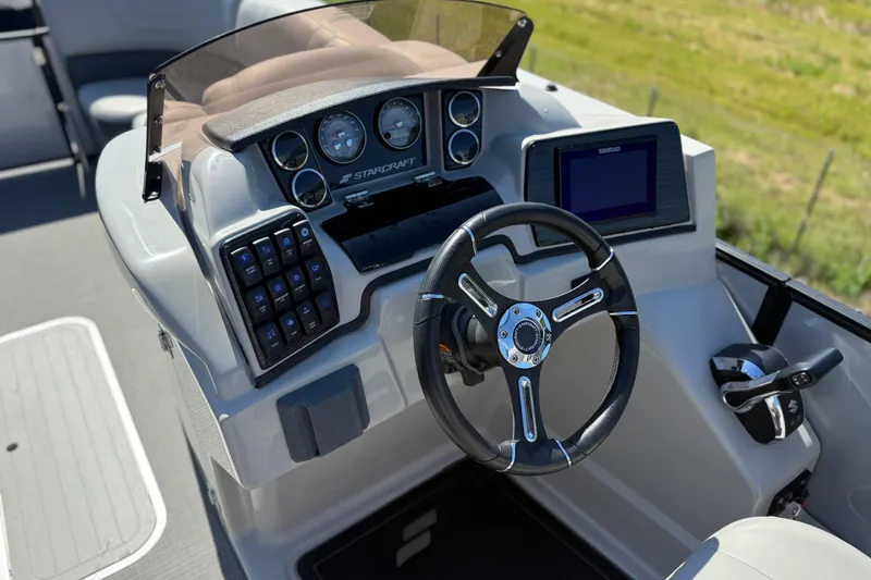 Slide: The Image of 2023 Starcraft SLS 5 boat dashboard with steering wheel and control panel. - 9