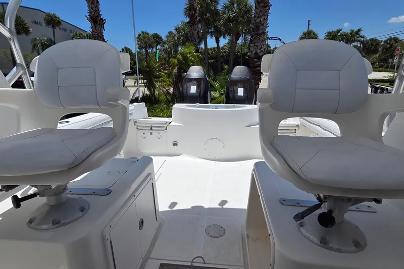 Slide: The Image of 2009 Sea Fox 256 Walk Around boat interior with dual seats and palm trees in background. - 12