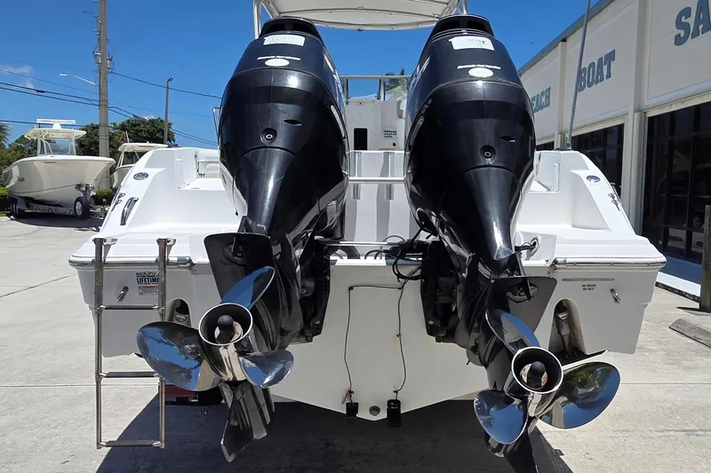 Slide: The Image of 2009 Sea Fox 256 Walk Around boat with dual outboard motors, docked outdoors. - 13