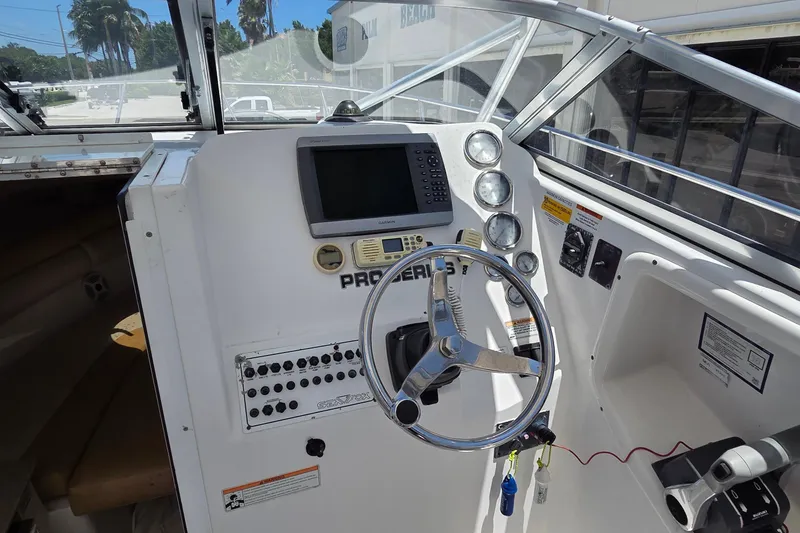 Slide: The Image of 2009 Sea Fox 256 Walk Around boat dashboard with steering wheel and navigation instruments. - 8