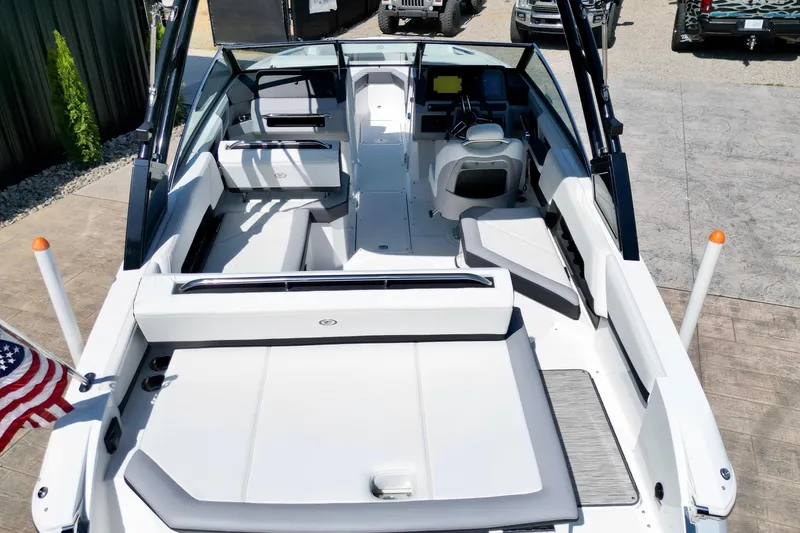 Slide: The Image of 2023 Cobalt R4 Outboard boat interior with seating and steering wheel, docked outdoors. - 11