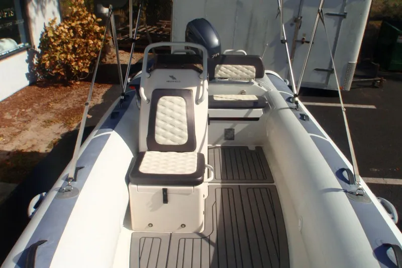 Slide: The Image of 2021 Highfield Sport 460 boat interior with cushioned seating and steering console. - 4