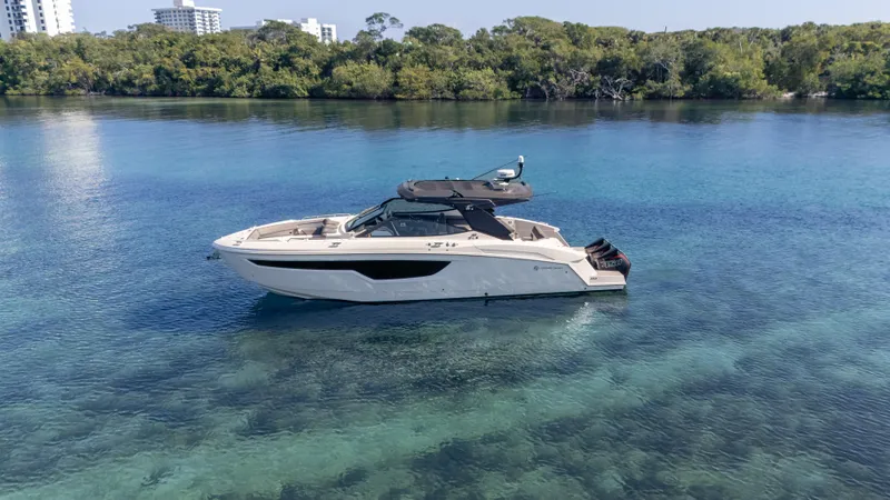 Slide: The Image of 2021 Cruisers Yachts 38 GLS OB 450R on clear water, surrounded by lush greenery. - 9