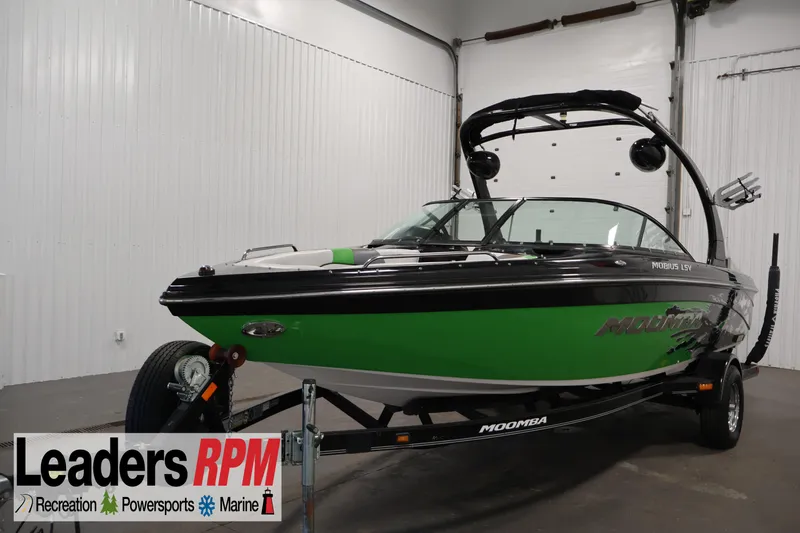 The Image of 2011 Moomba Mobius LSV boat in showroom, green and black design, Leaders RPM logo visible. - 0