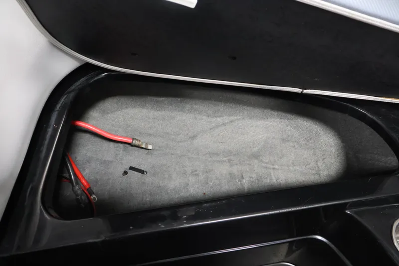Slide: The Image of 2011 Moomba Mobius LSV storage compartment with exposed wiring and black interior. - 13