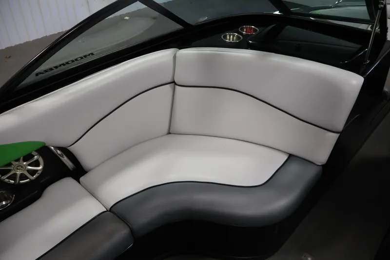 Slide: The Image of 2011 Moomba Mobius LSV boat interior with white and gray seating, cup holders, and speaker. - 32