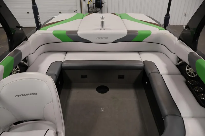 Slide: The Image of 2011 Moomba Mobius LSV boat interior with green and gray seating, spacious layout. - 34