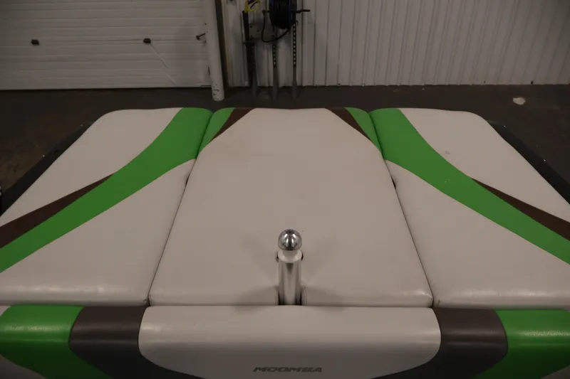 Slide: The Image of 2011 Moomba Mobius LSV boat interior with green and brown accents in a garage setting. - 36