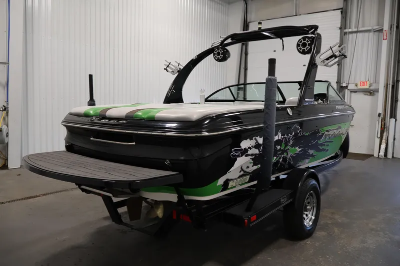 Slide: The Image of 2011 Moomba Mobius LSV boat with custom graphics in a garage setting. - 4