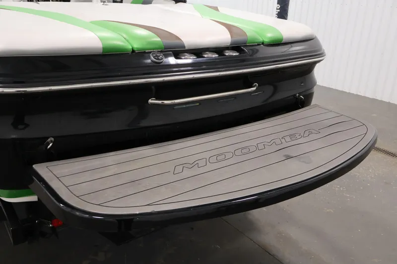Slide: The Image of 2011 Moomba Mobius LSV boat rear platform with green and white accents. - 44