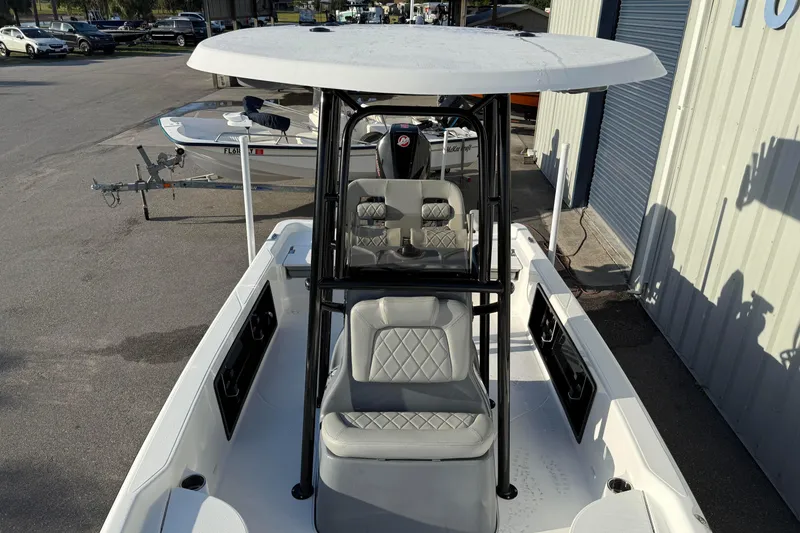 Slide: The Image of 2026 Blazer Bay PURE BAY 2200 boat with T-top and seating, parked outdoors. - 14