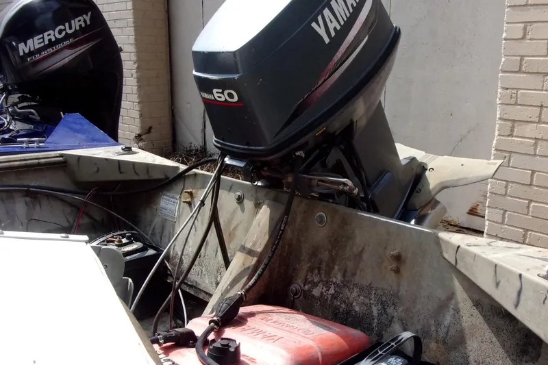 Slide: The Image of 2001 Xpress 1650VJF boat with Yamaha and Mercury outboard motors, parked near a brick wall. - 4