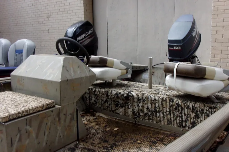 Slide: The Image of 2001 Xpress 1650VJF boat with dual outboard motors, parked indoors. - 6