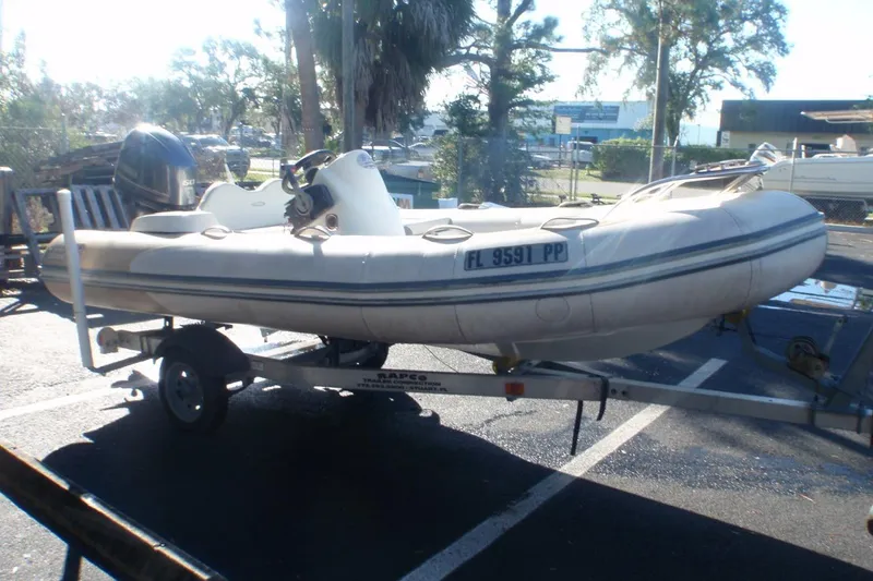 Slide: The Image of 2014 Zodiac Yachtline 420 inflatable boat on trailer in sunny outdoor setting. - 3