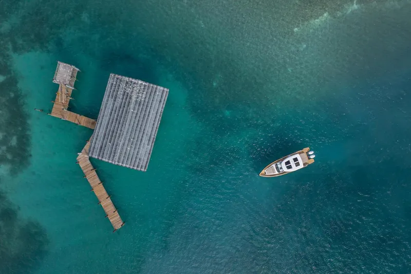 Slide: The Image of Aerial view of Fjord 41 XP yacht near a wooden dock on turquoise water, 2026 model. - 11