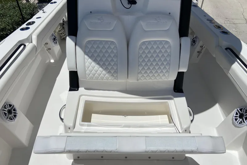 Slide: The Image of 2026 Regulator 28 boat interior with white cushioned seating and storage compartment. - 16
