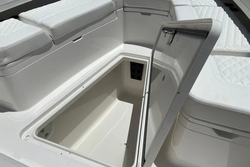 Slide: The Image of Open storage compartment on 2026 Regulator 28 boat with cushioned seating. - 17