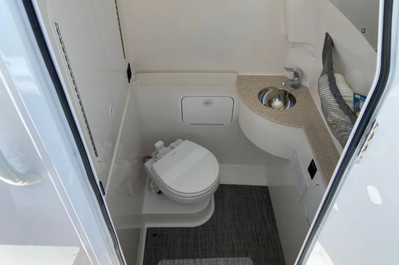 Slide: The Image of 2026 Regulator 28 boat bathroom with toilet, sink, and storage area. - 22