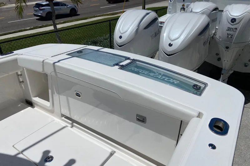 Slide: The Image of 2026 Regulator 28 boat with powerful outboard engines, parked near a road. - 3