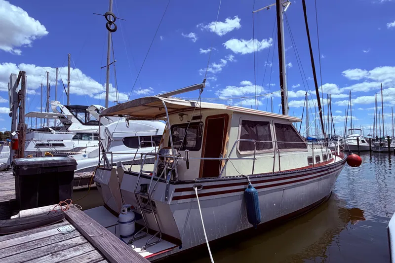 Slide: The Image of 1985 Lancer Yachts 40 Motorsailer docked at marina under clear blue sky. - 3