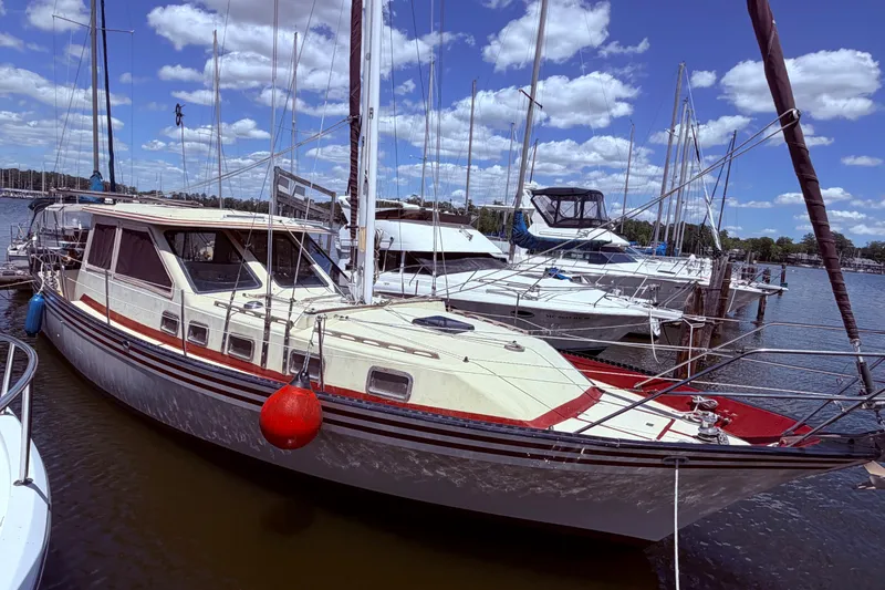 Slide: The Image of 1985 Lancer Yachts 40 Motorsailer docked at marina under blue sky. - 4
