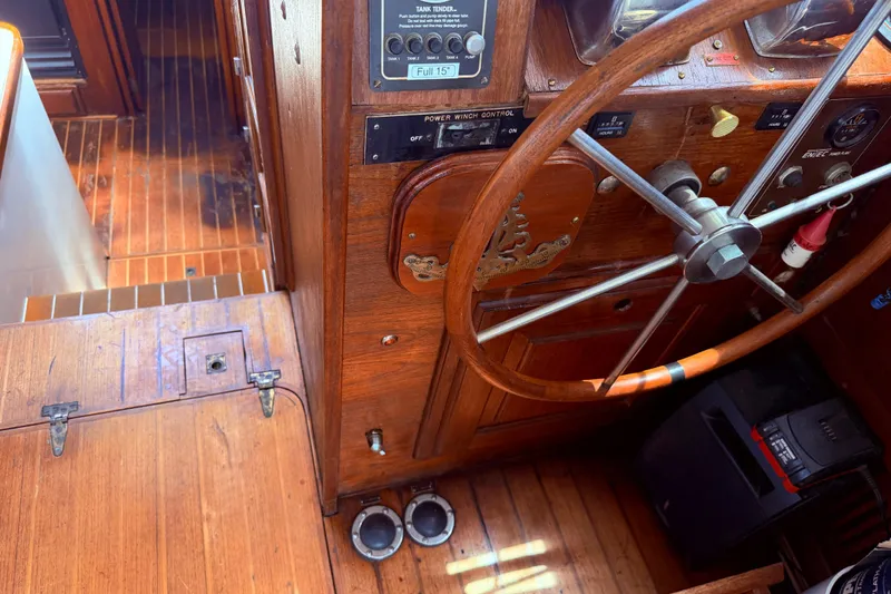 Slide: The Image of Interior helm of 1985 Lancer Yachts 40 Motorsailer, featuring wooden steering wheel and control panel. - 42