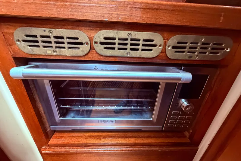 Slide: The Image of Built-in oven in 1985 Lancer Yachts 40 Motorsailer galley, featuring wooden cabinetry. - 56