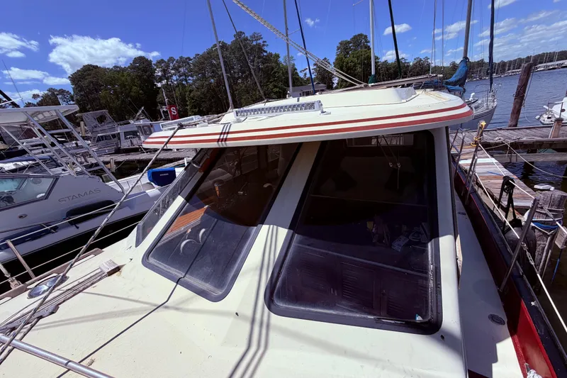 Slide: The Image of 1985 Lancer Yachts 40 Motorsailer docked at a marina under a clear blue sky. - 6