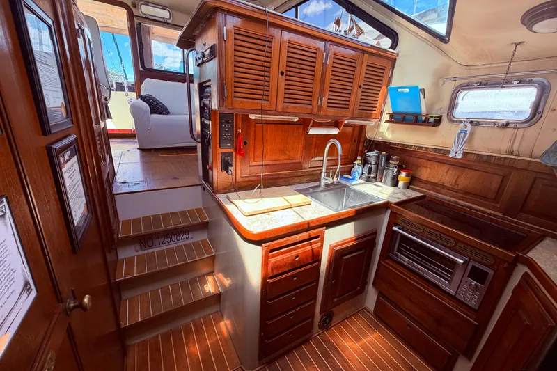 Slide: The Image of Interior of 1985 Lancer Yachts 40 Motorsailer with wooden cabinetry and compact kitchen. - 63