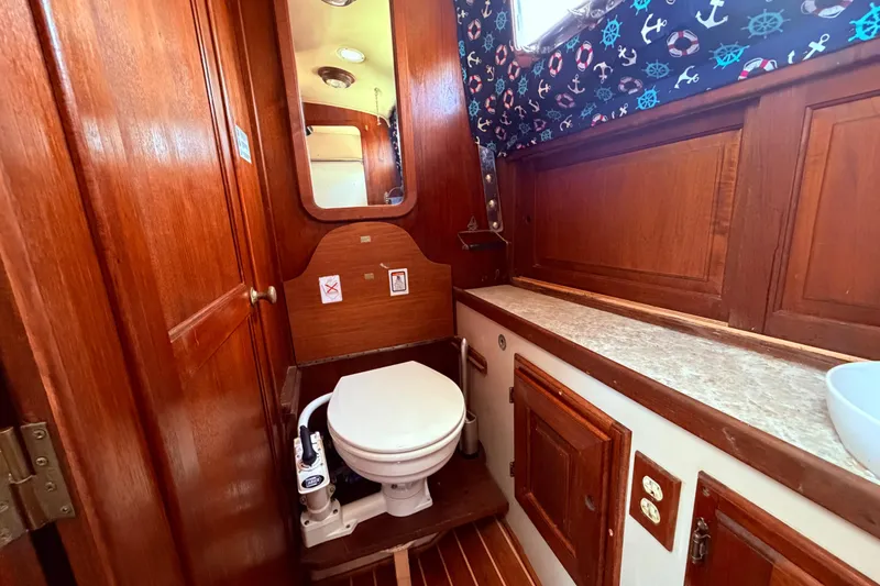 Slide: The Image of Interior of 1985 Lancer Yachts 40 Motorsailer bathroom with wooden cabinetry and nautical decor. - 69