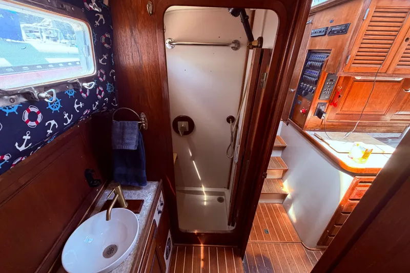 Slide: The Image of 1985 Lancer Yachts 40 Motorsailer bathroom with nautical decor and wooden cabinetry. - 70