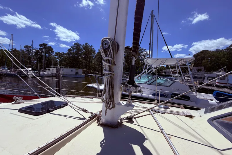 Slide: The Image of 1985 Lancer Yachts 40 Motorsailer docked, showcasing deck and rigging under a clear blue sky. - 9