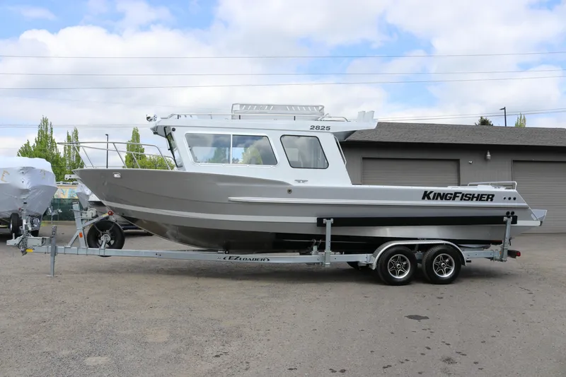 Slide: The Image of 2026 KingFisher 2825 Coastal Express boat on trailer, parked outdoors. - 3