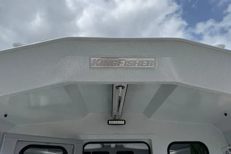 Slide: The Image of 2026 KingFisher 2825 Coastal Express boat exterior with logo under cloudy sky. - 37