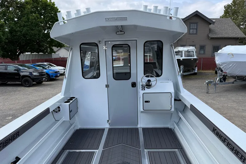 Slide: The Image of 2026 KingFisher 2825 Coastal Express boat interior with steering wheel and storage compartments. - 4