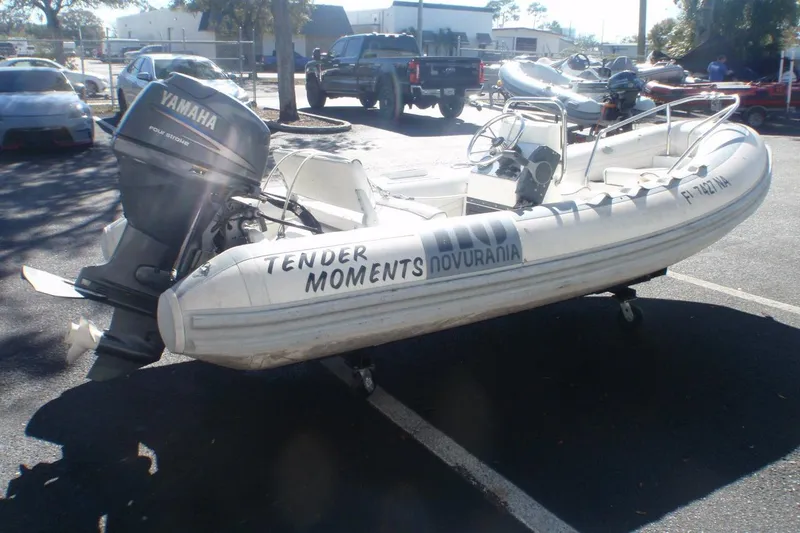 The Image of 2003 Novurania DL 400 inflatable boat with Yamaha outboard motor in a parking lot. - 1