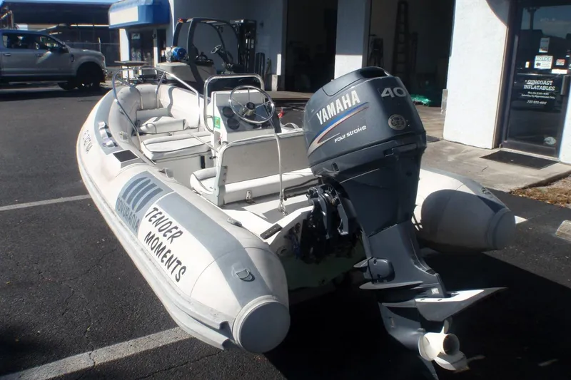 Slide: The Image of 2003 Novurania DL 400 inflatable boat with Yamaha 40 outboard motor, parked outdoors. - 4