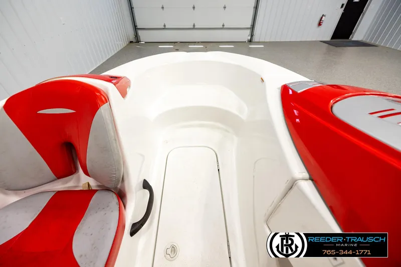 Slide: The Image of 2007 Sea Doo 150 Speedster interior with red and white seating in a garage. - 14