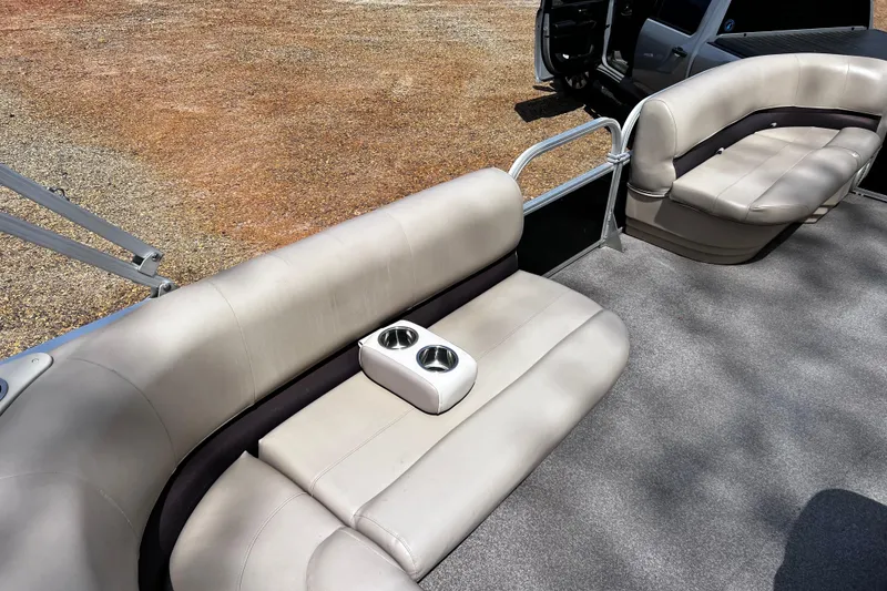 Slide: The Image of 2017 Sun Tracker Party Barge 22 DLX interior with beige seating and cup holders. - 10