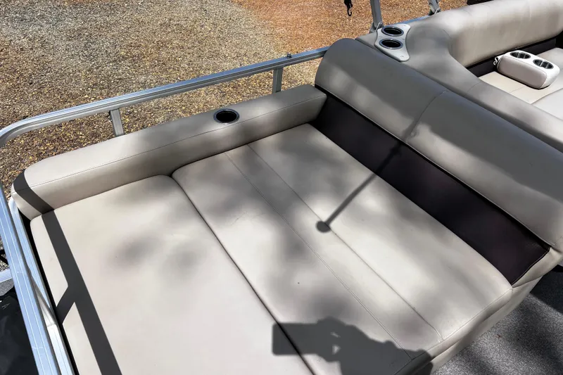 Slide: The Image of 2017 Sun Tracker Party Barge 22 DLX seating area with cup holders and beige upholstery. - 12