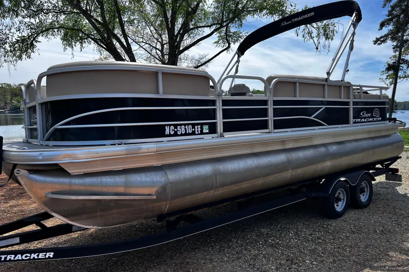 Slide: The Image of 2017 Sun Tracker Party Barge 22 DLX pontoon boat on trailer by a lake. - 2